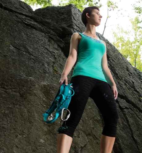 Participant Sonya - person with short dark hair standing tall on a large rock