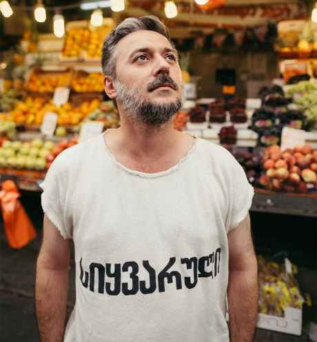 Deconstructing Stigma participant Shimon - person stands in fruit market