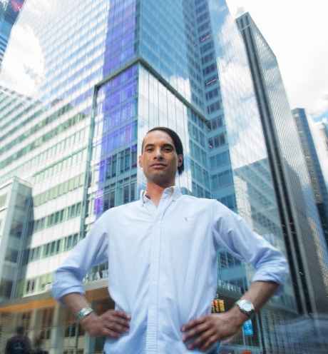 Participant Paul - person with short dark hair wearing a white shirt in front of a city skyline