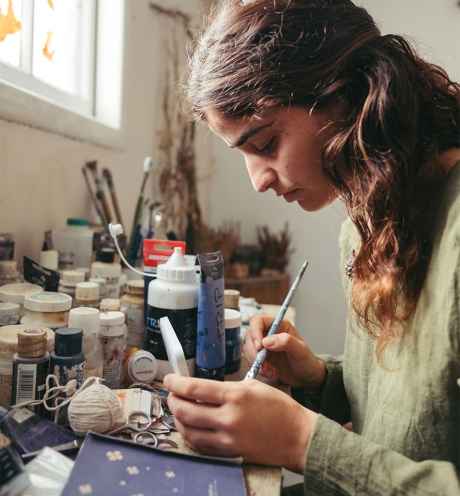 Deconstructing Stigma participant Yaqueen - person paints in an art studio