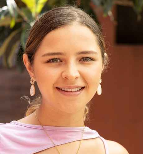 Participant Alejandra - person with long brown hair tied back wearing a pink shirt and smiling