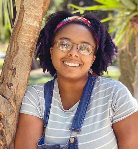Participant Chezia leaning against a tree