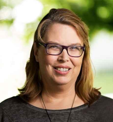 Participant Laura with blonde hair and glasses smiling