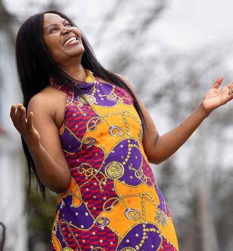 Deconstructing Stigma participant Dorothy - person stands outside with arms raised, head up