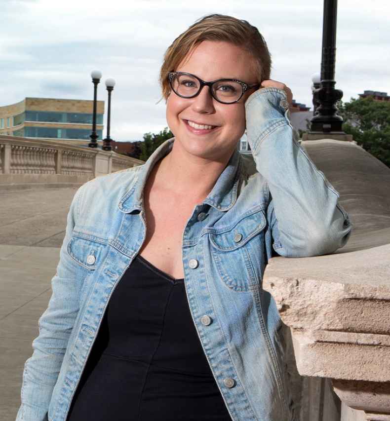 Participant Kelsey - person in glasses wearing a denim jacket and smiling