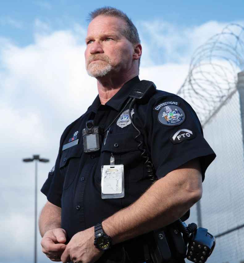 Participant Kevin - person in police uniform in front of a bright blue sky with clouds