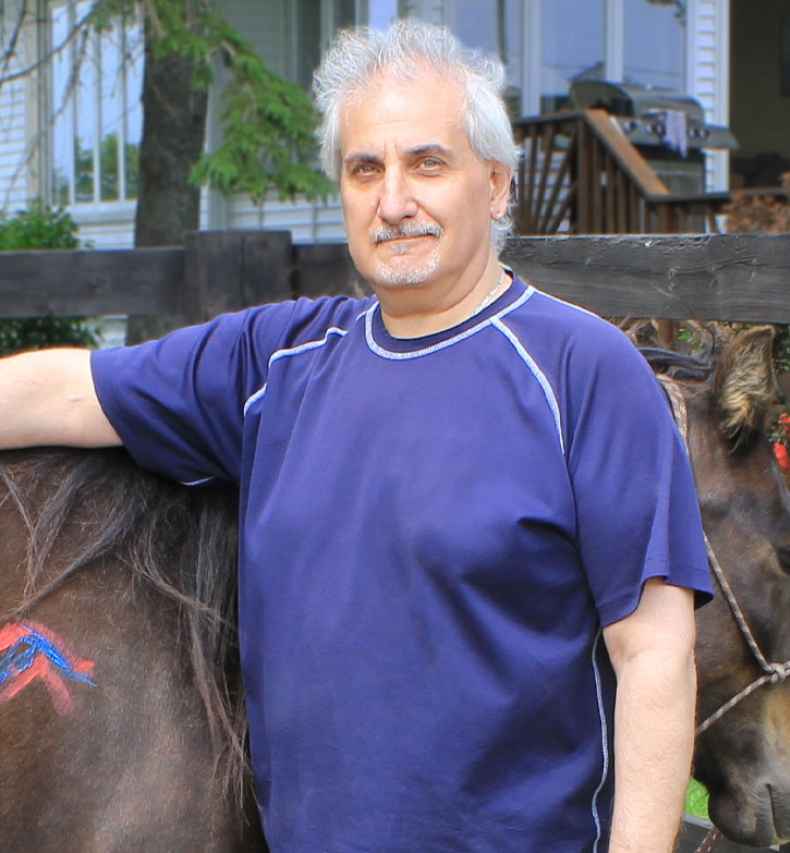 Participant Leo - person with short white hair standing next to a horse, the horse has colorful shapes painted on it