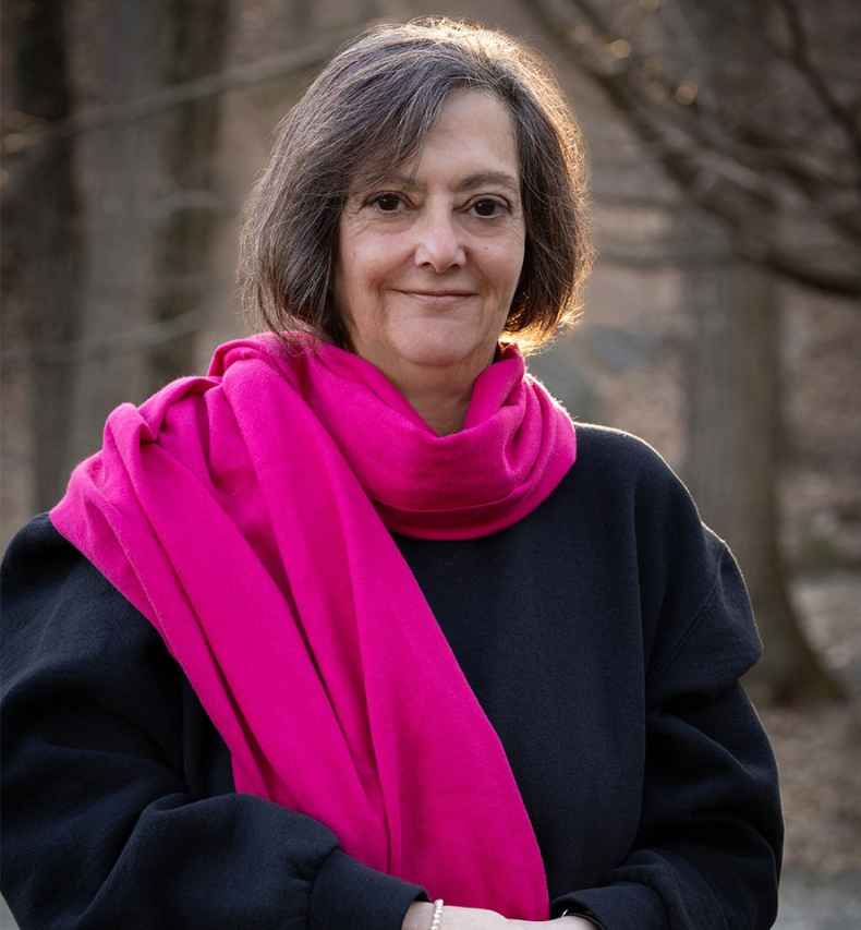 Participant Elissa standing outside wearing a black sweatshirt and a pink scarf