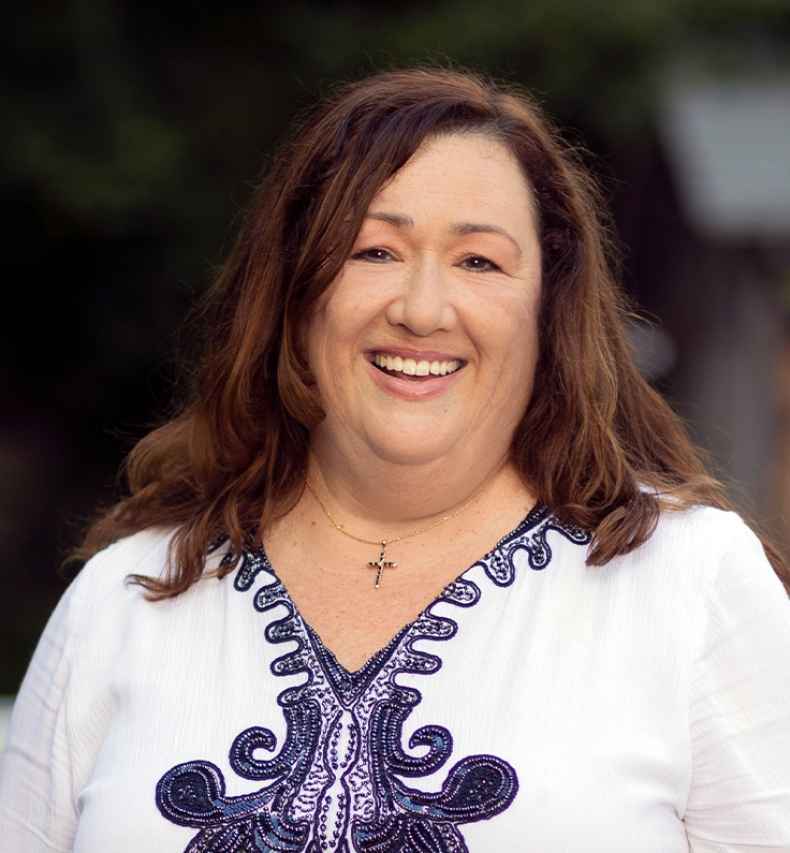 Participant Michele - person with long brown hair smiling outside
