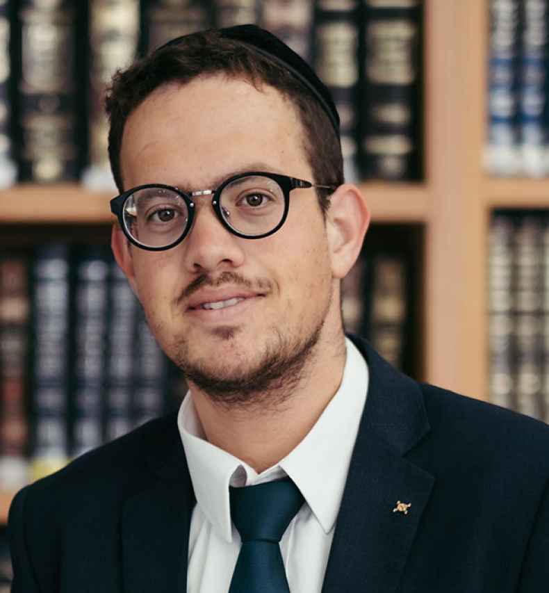 Deconstructing Stigma participant David - Person stands in front of shelves of books