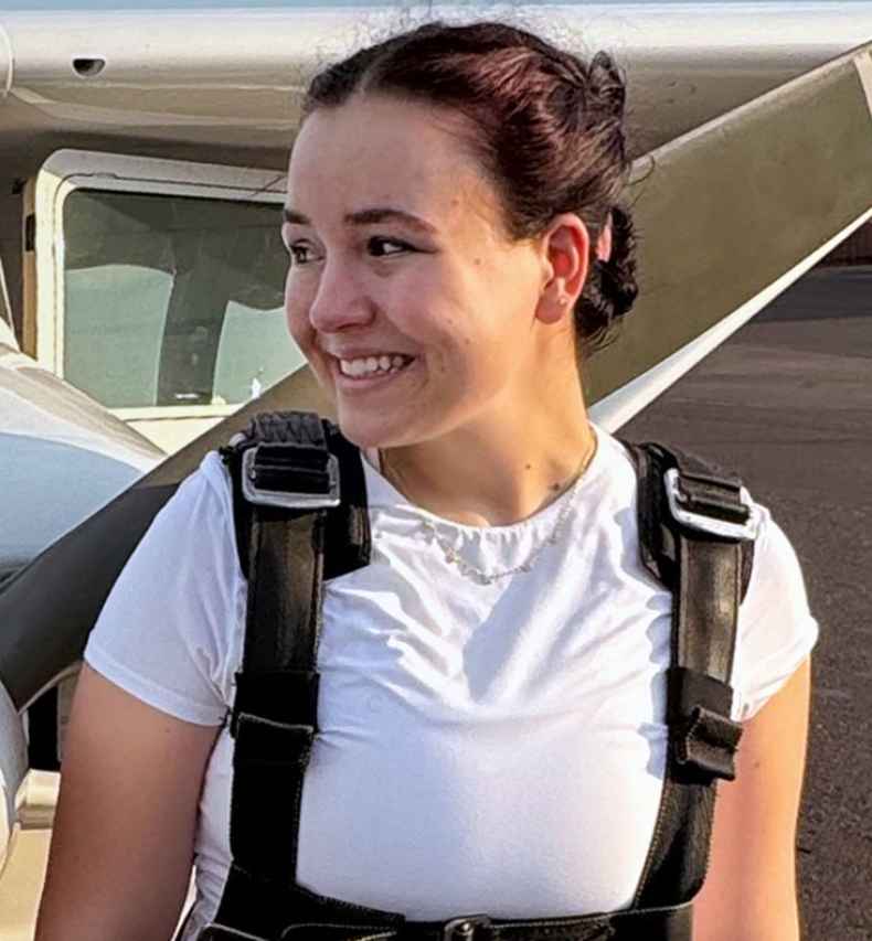 Participant Daria standing in front of a propeller plane