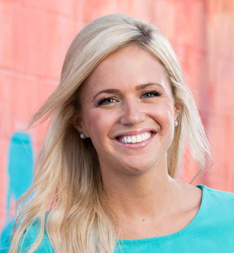 Participant Meg - person with long blond hair smiling in front of a colorful painted wall