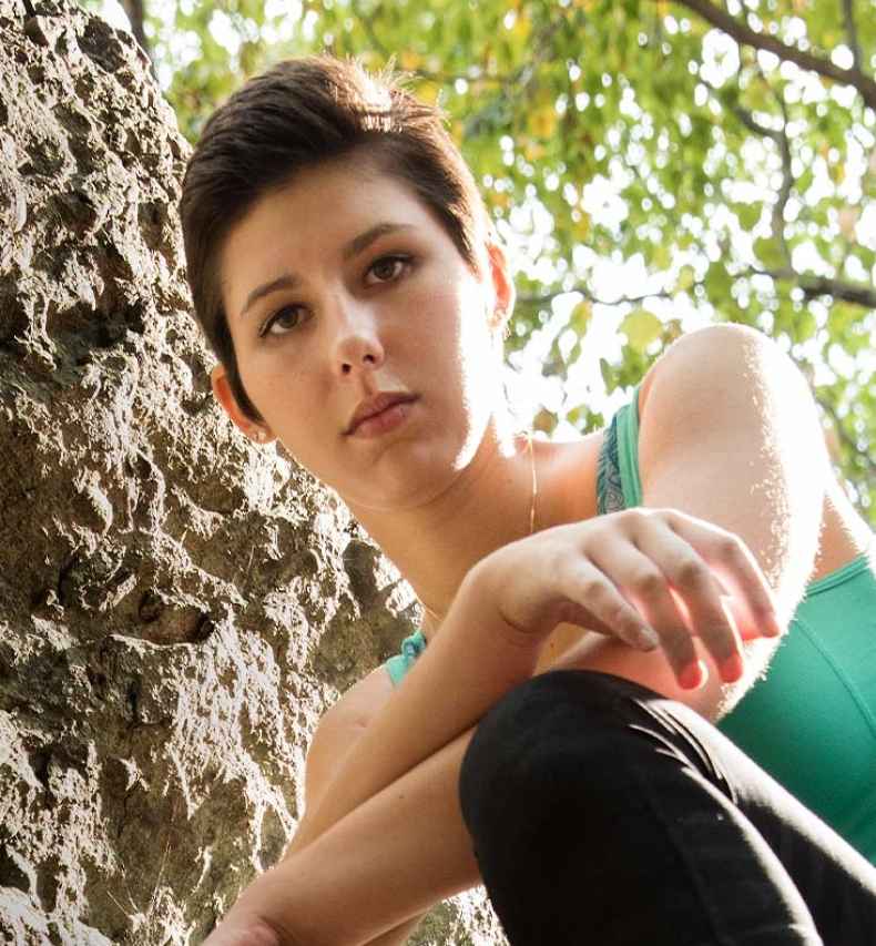 Participant Sonya - person with short dark hair on a large rock