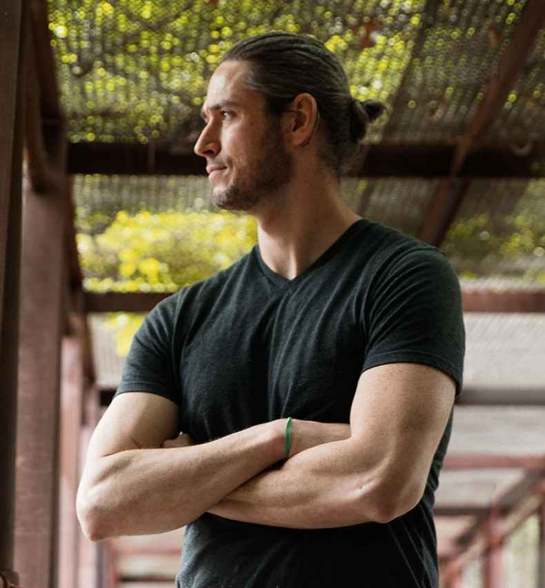 Deconstructing Stigma participant Sean - person stands in chainlink fence bridge