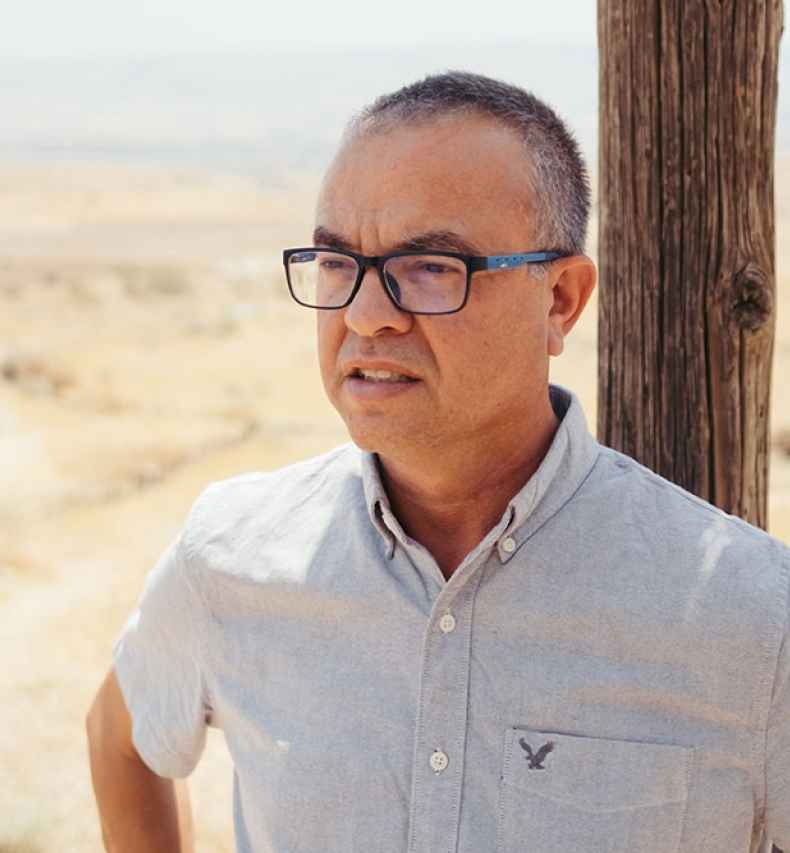 Deconstructing Stigma participant Shay - Person stands outside on desert sand