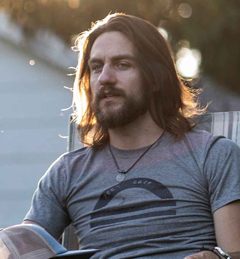 Participant Travis - person with long dark hair sitting outside