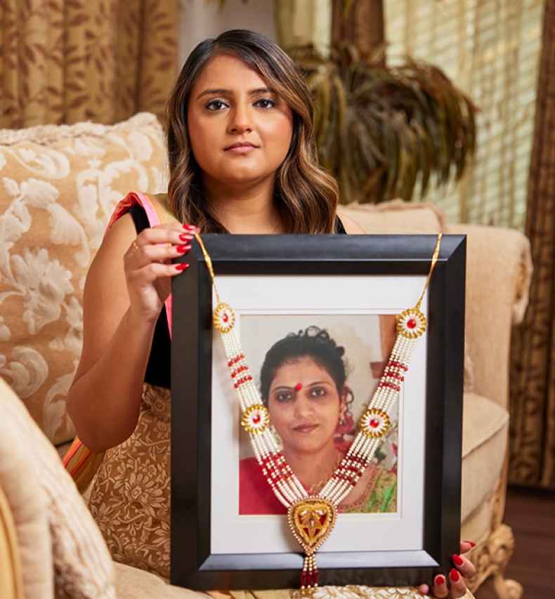 Participant Dimple - person with long wavy hair holding a framed photograph