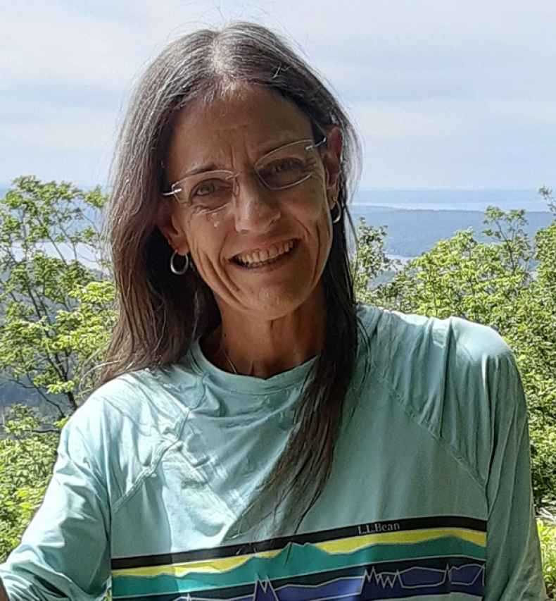 Participant Dani - person with long dark hair smiling outside