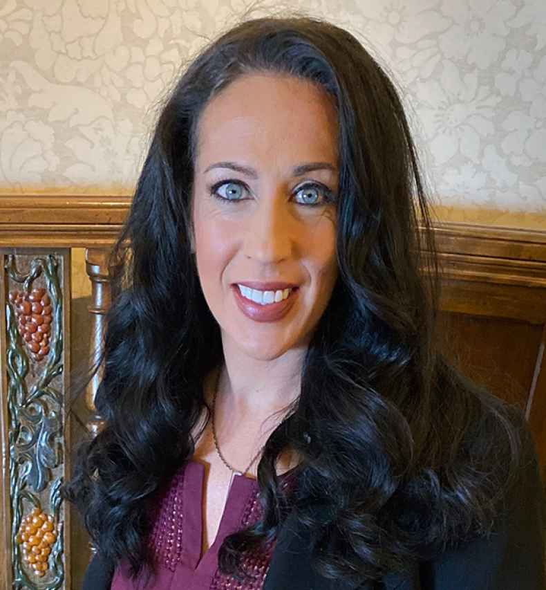 Participant Cali - person with long dark hair wearing black and smiling