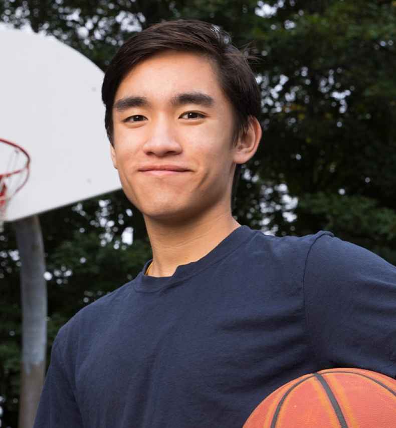 Participant Joel - person with short dark hair smiling outside with a basketball