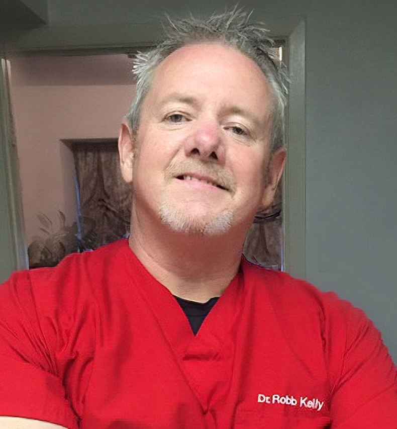 Participant Robb wearing a red doctors scrub smiling