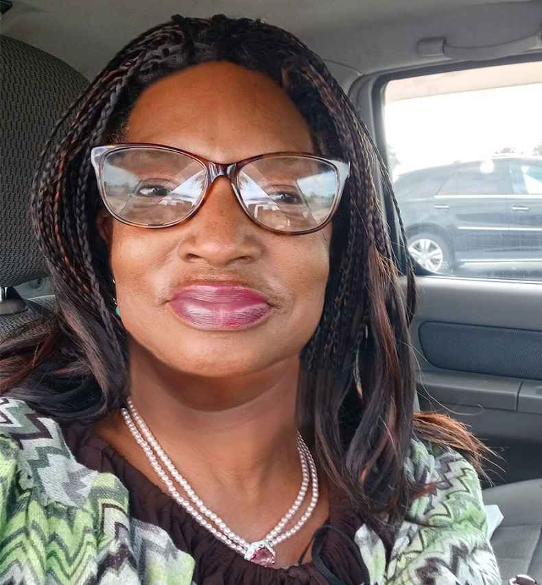 Participant Sylvia sitting in a car wearing glasses