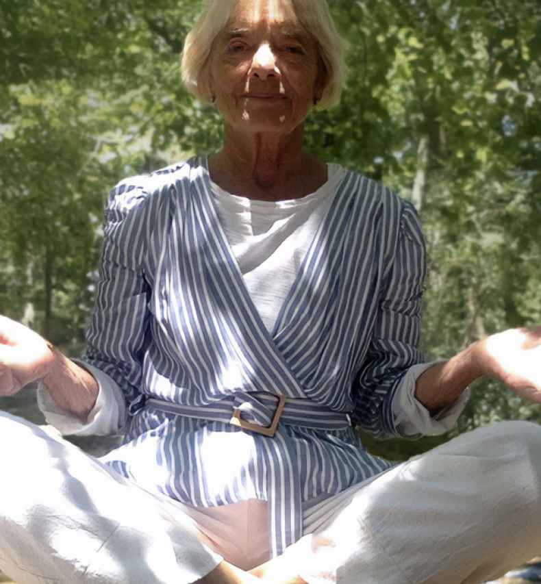 Participant Vicky sitting on the ground cross legged with her palms up