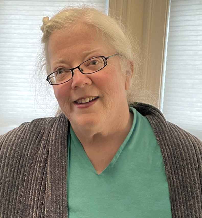 Deconstructing Stigma participant Francesca - person with white hair and glasses in green shirt and gray sweater