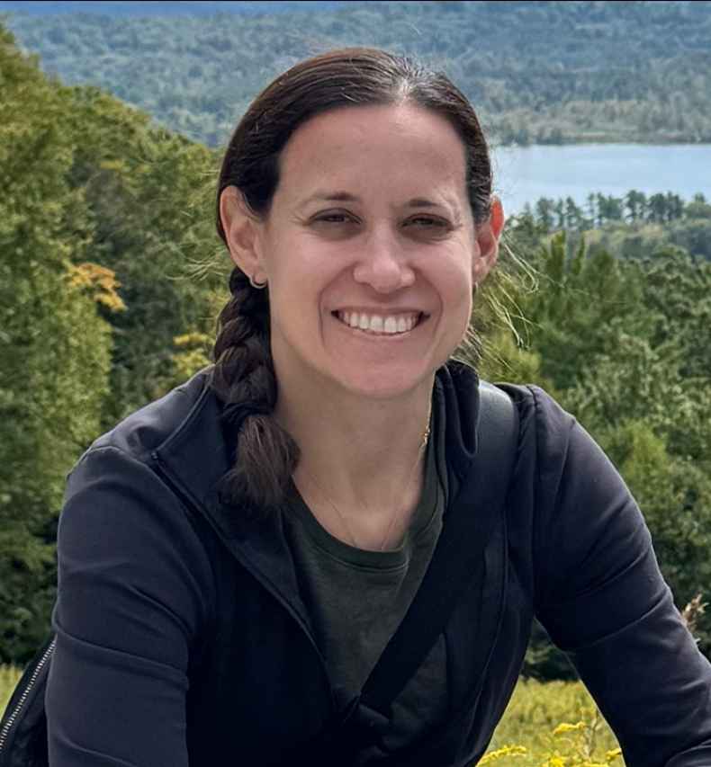 Deconstructing Stigma participant Lauren - person poses with lake, trees in background