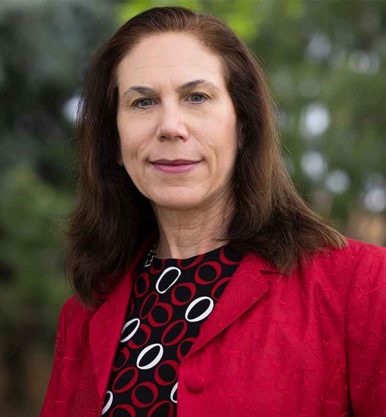 Deconstructing Stigma participant Eva - person in red pattern dress and red jacket outside