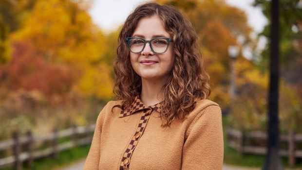 Participant Courtney - person with long wavy hair and glasses smiling