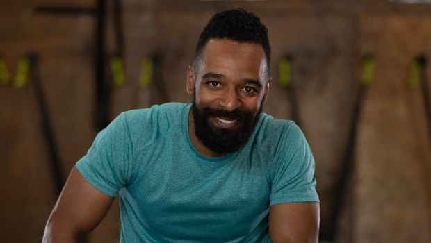 Participant Christopher - person with short dark hair and facial hair in a room with exercise equipment