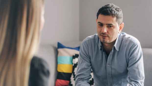 Person sits on couch talking to therapist