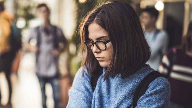 Young person looks anxious in a school hallway