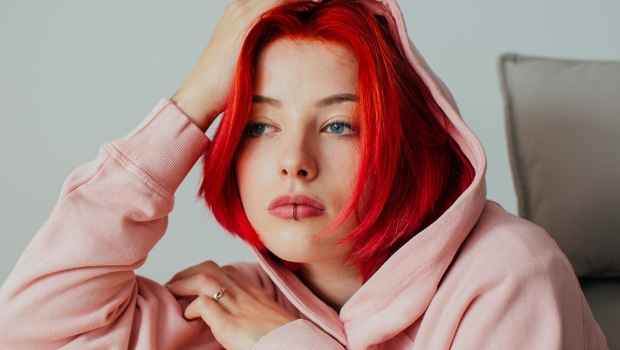 Teen girl with red hair leans on table