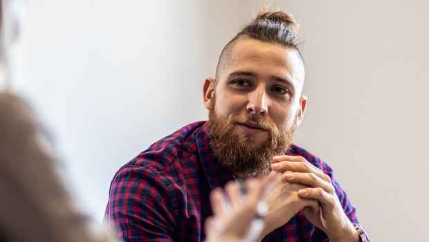 Person in plaid shirt talking to clinician