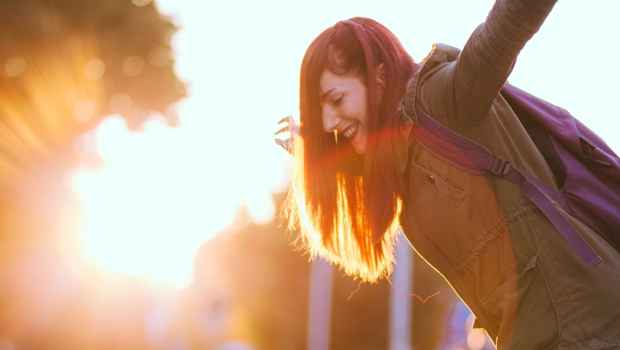 Teen dancing outside with sun glare behind