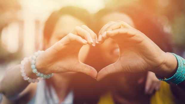 Two women holding their hands together to make a heart shape