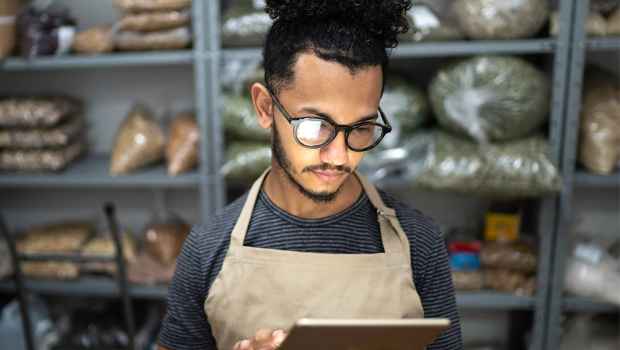 Worker at store scrolls on tablet