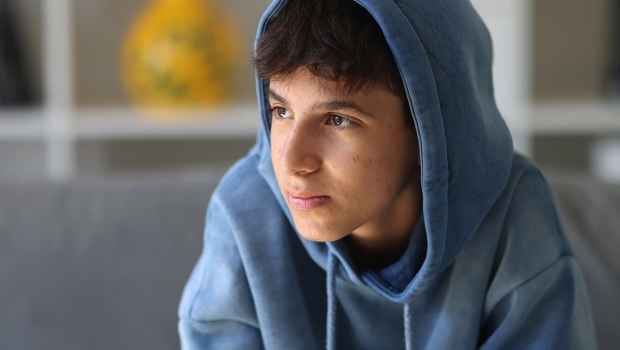 Young person in hoodie looking off