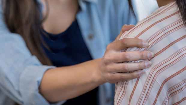 A hand on a shoulder in consolation