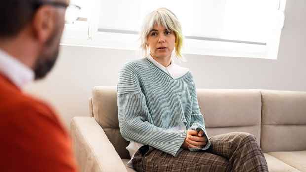 blonde woman seated, talking to a therapist