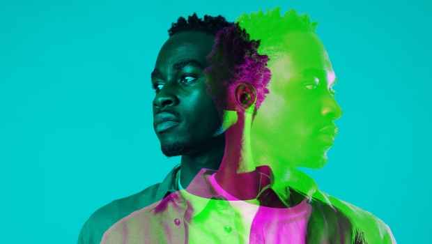 A man looking off to the side against a teal background, there is also a green and pink overlay of him looking the other way