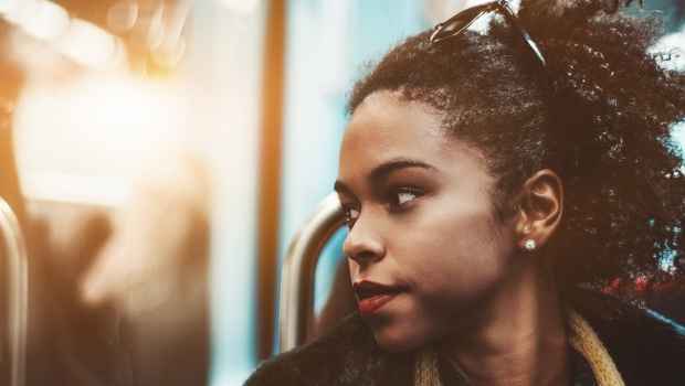 young black woman on subway looking out window
