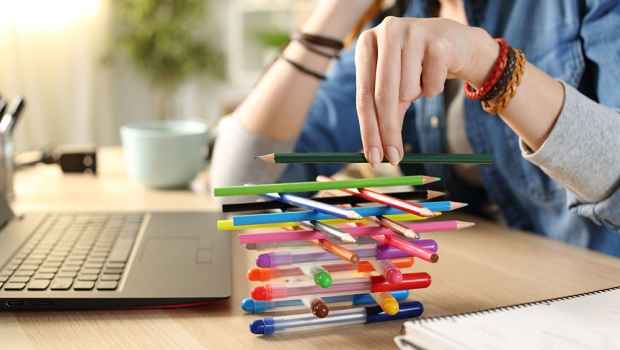 Balancing colorful pens and pencils on desk