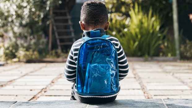 Child sitting with backpack