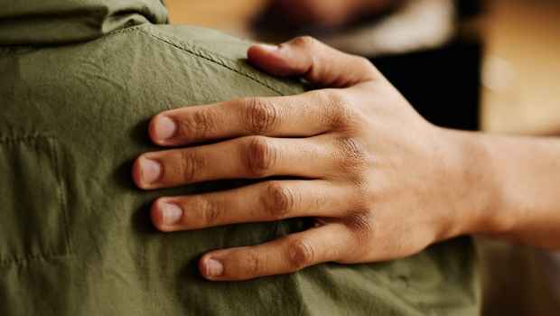 Comforting hand rests on a shoulder