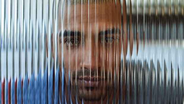 Blurred face behind lined glass