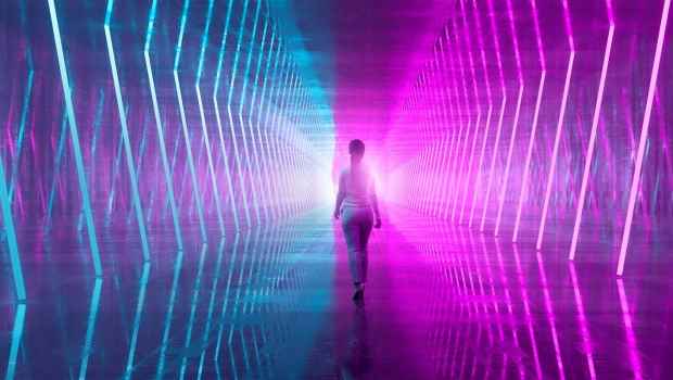 Figure walking in high tech looking pink and blue hallway