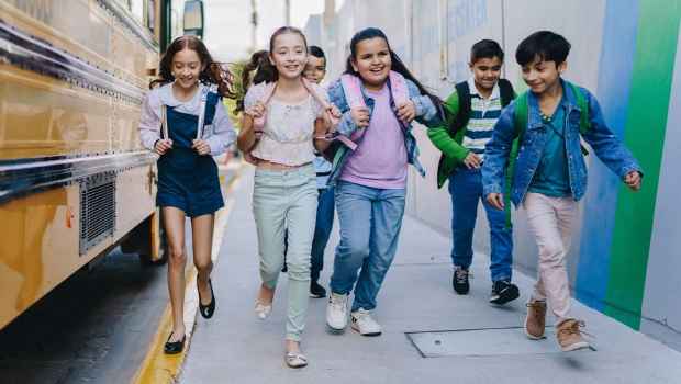 kids running by school bus